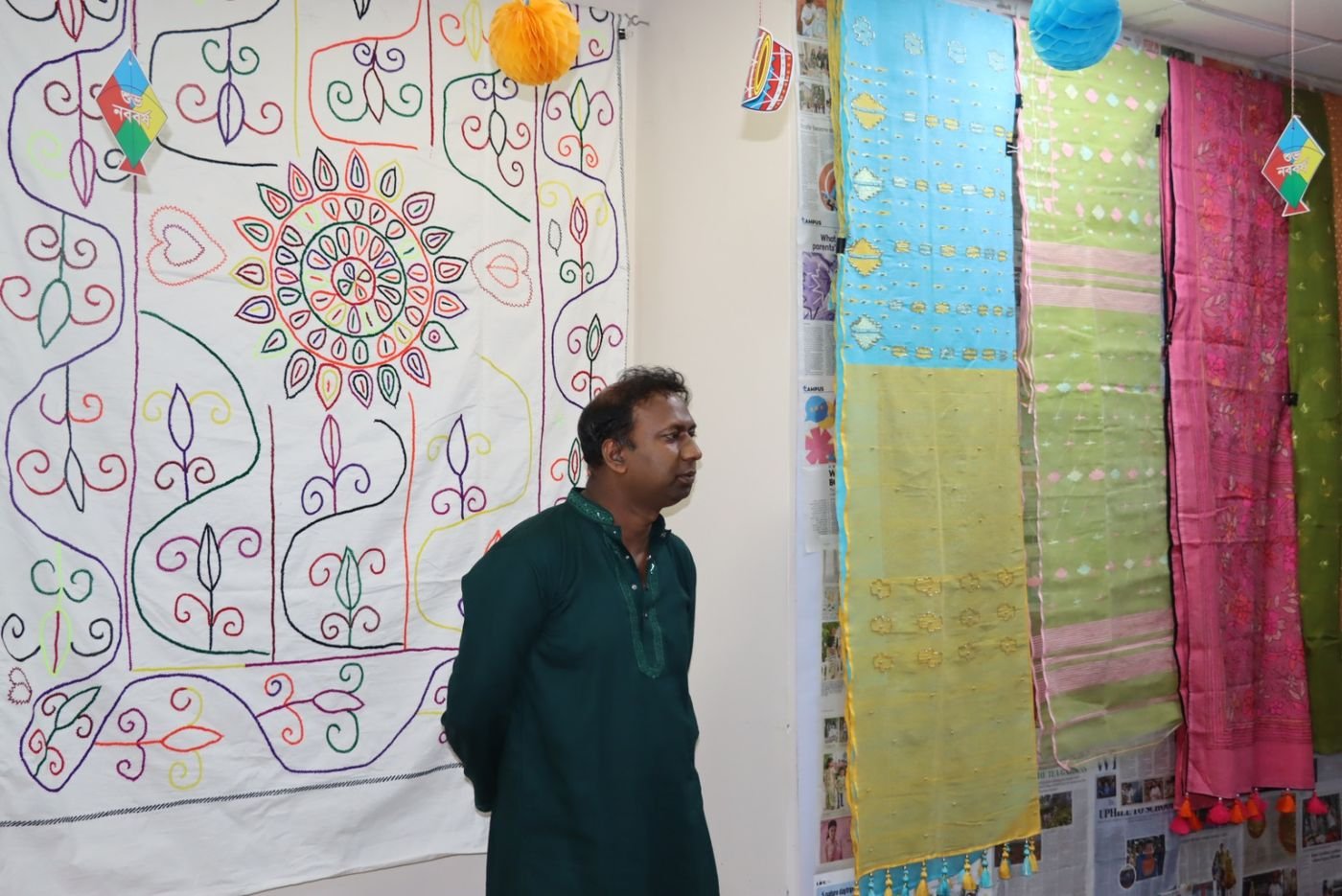 A guest looking at the Nakshi Kantha and sharees made by the makers
